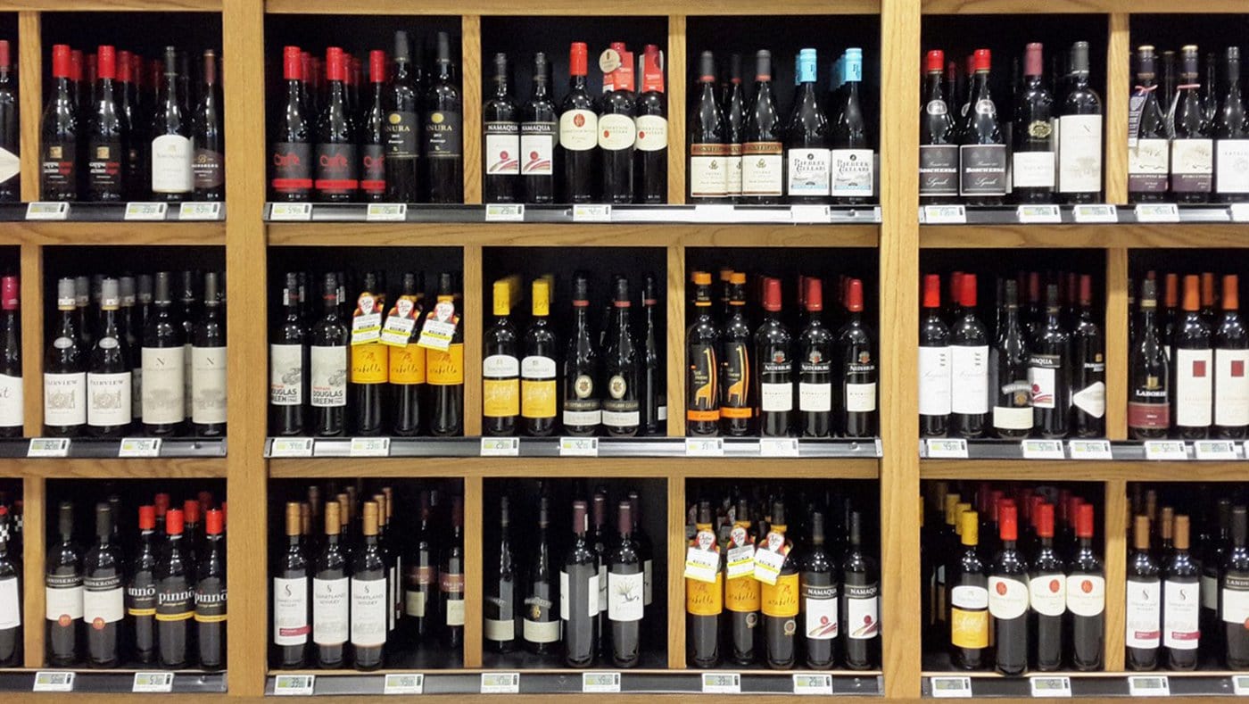 A shelf of many different kinds of wine, all with different labels and designs.