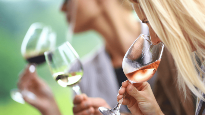 Three People Stand In A Row, Each With A Wine Glass With Various Types Of Wine Inside.