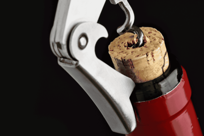 Closeup of wine bottle being uncorked.